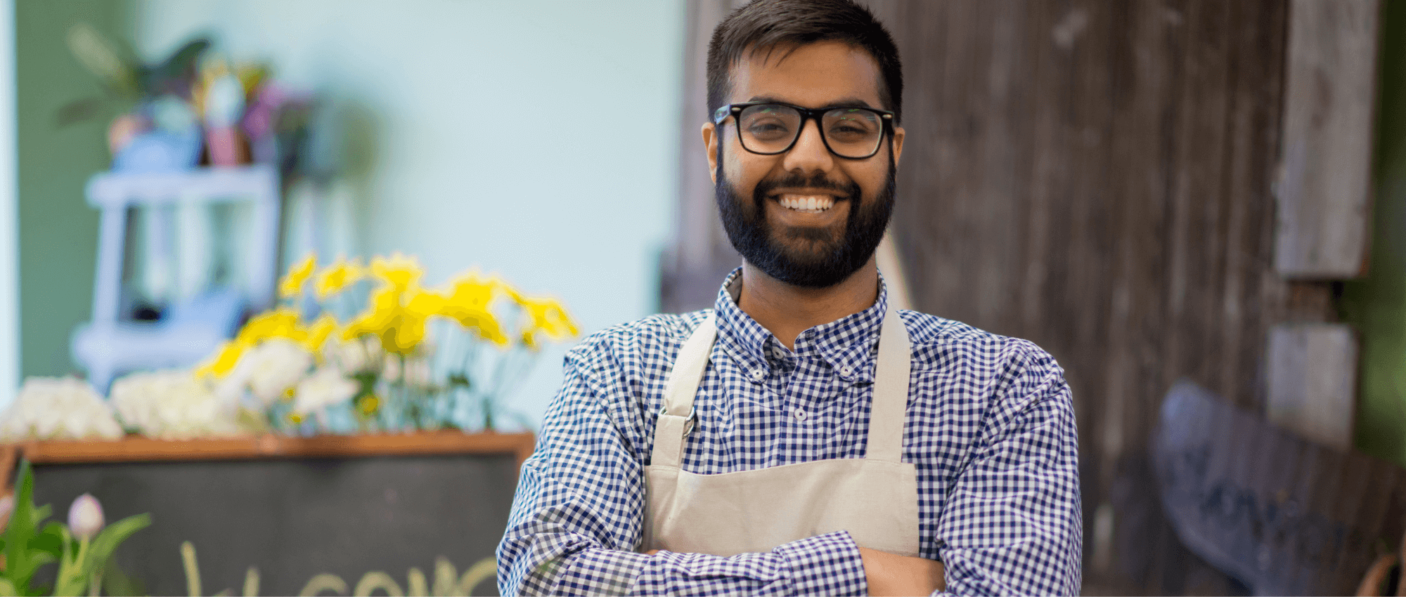 man in apron standing in flower shop
