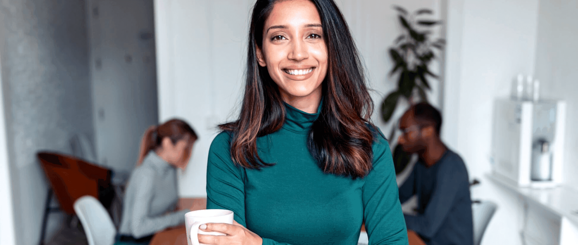 smiling woman holding coffee in office