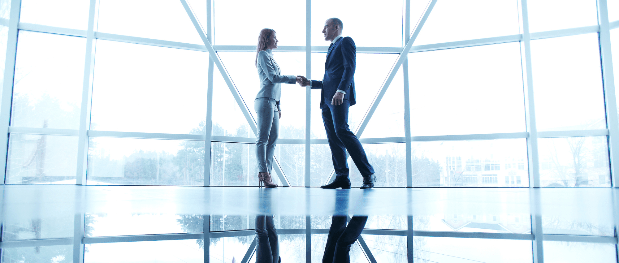 man and woman shaking hands in giant office