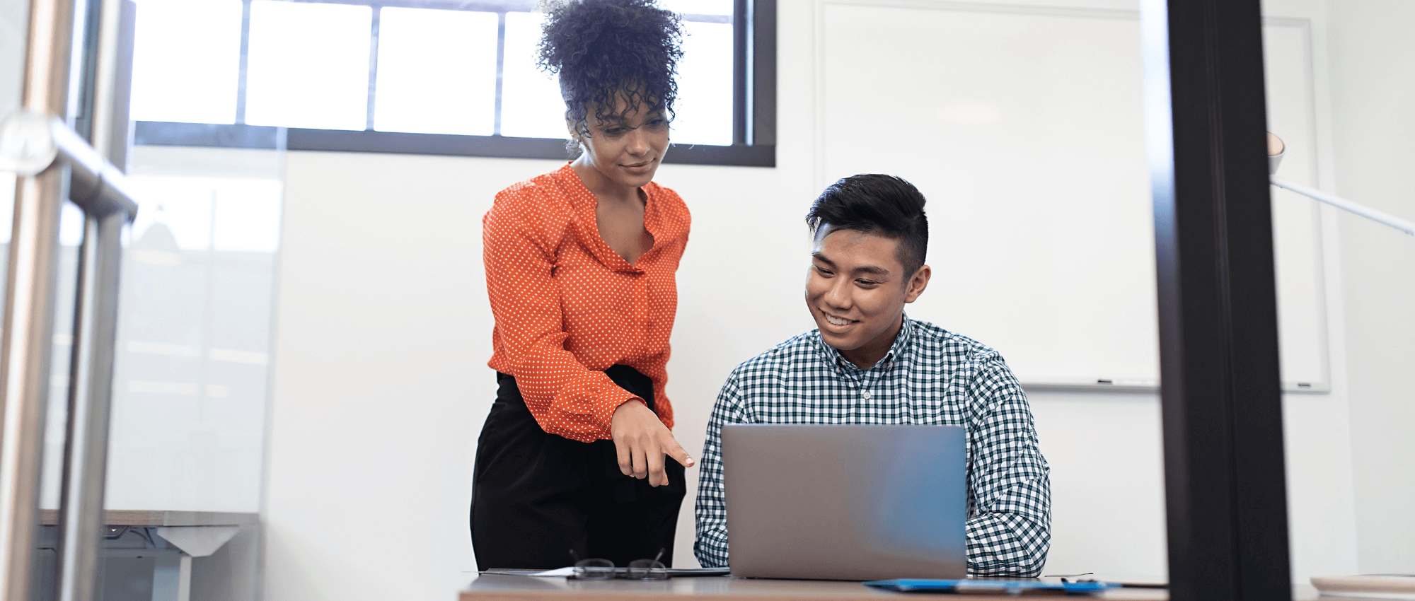 woman helping man on laptop