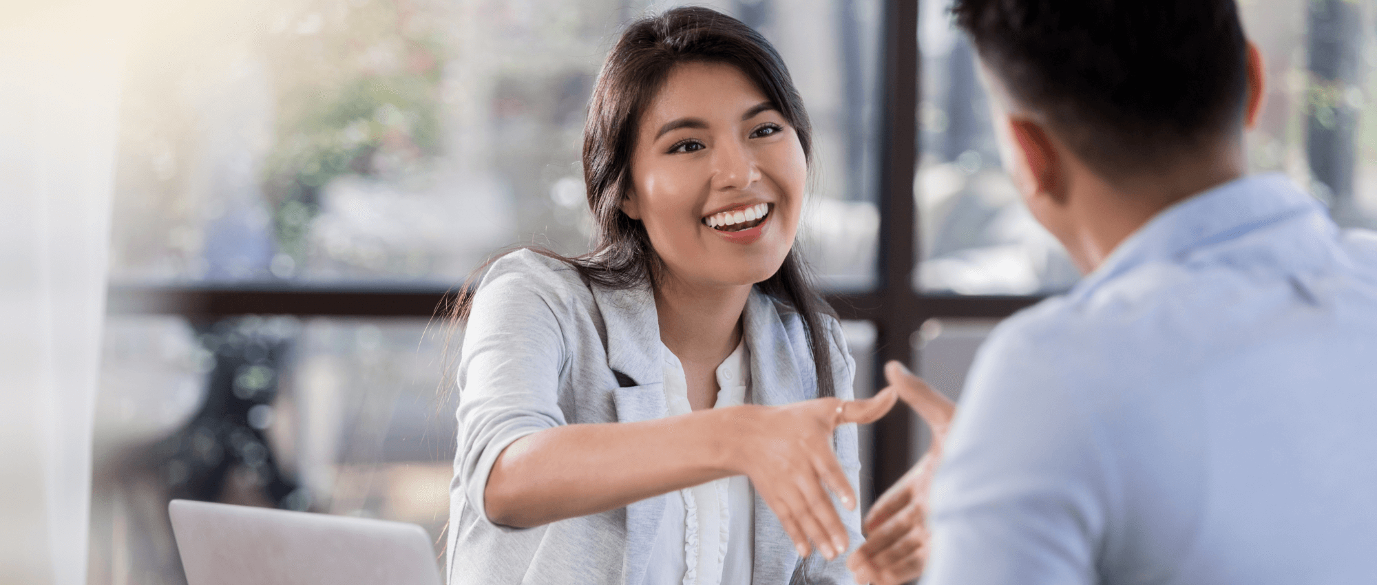A newcomer female shaking hands with another person