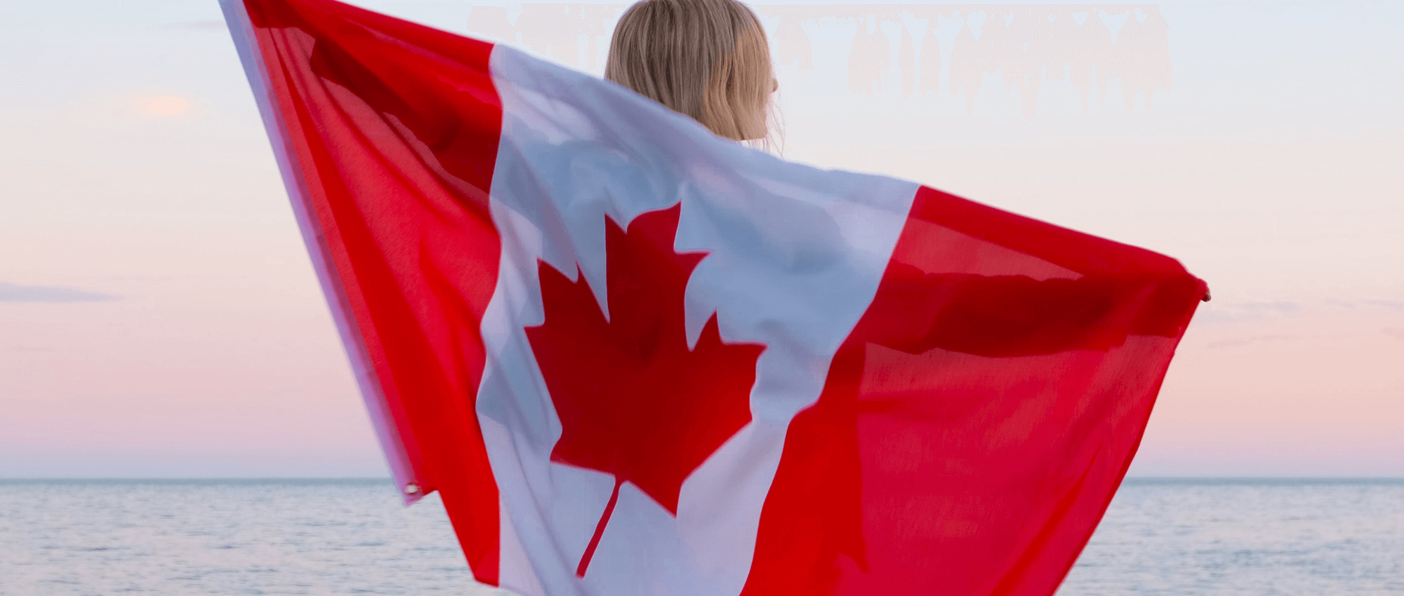 A blond female holding the Canadian Flag