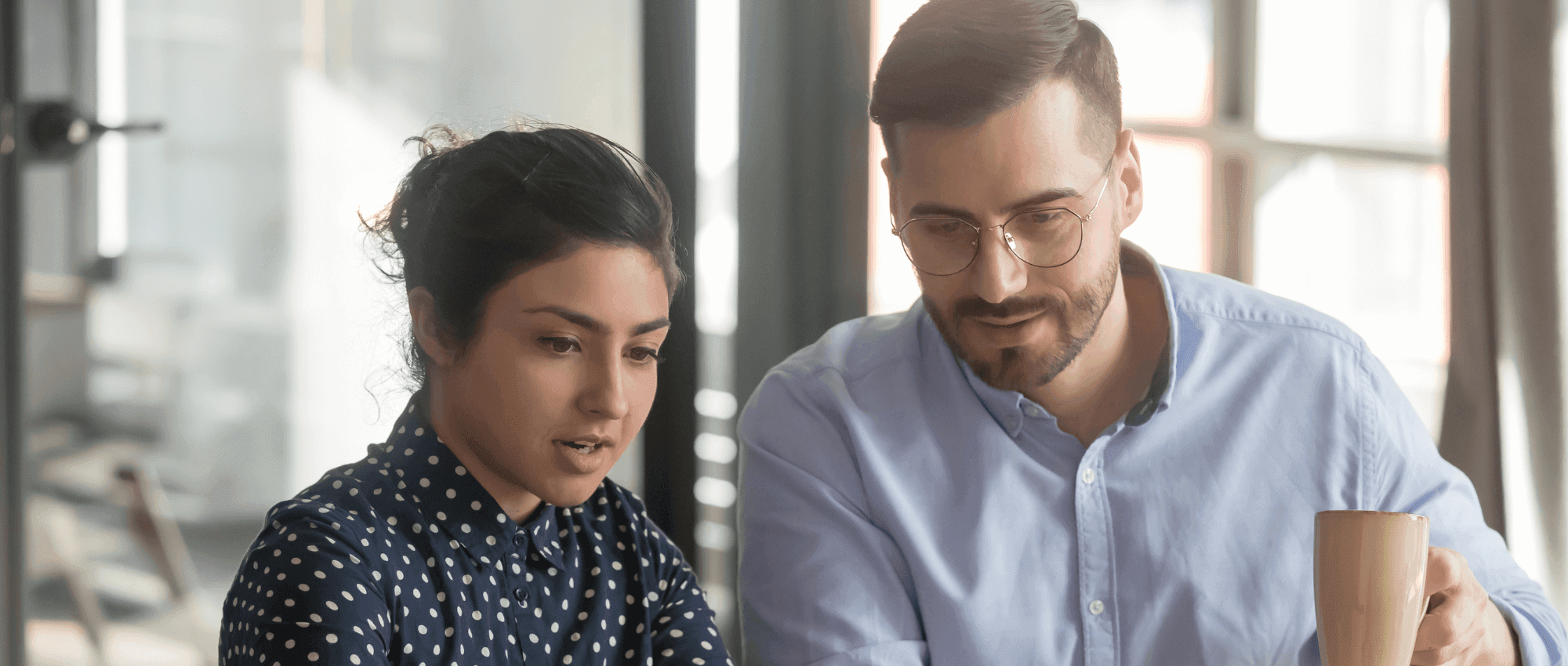 A mentor and a professional looking at a project
