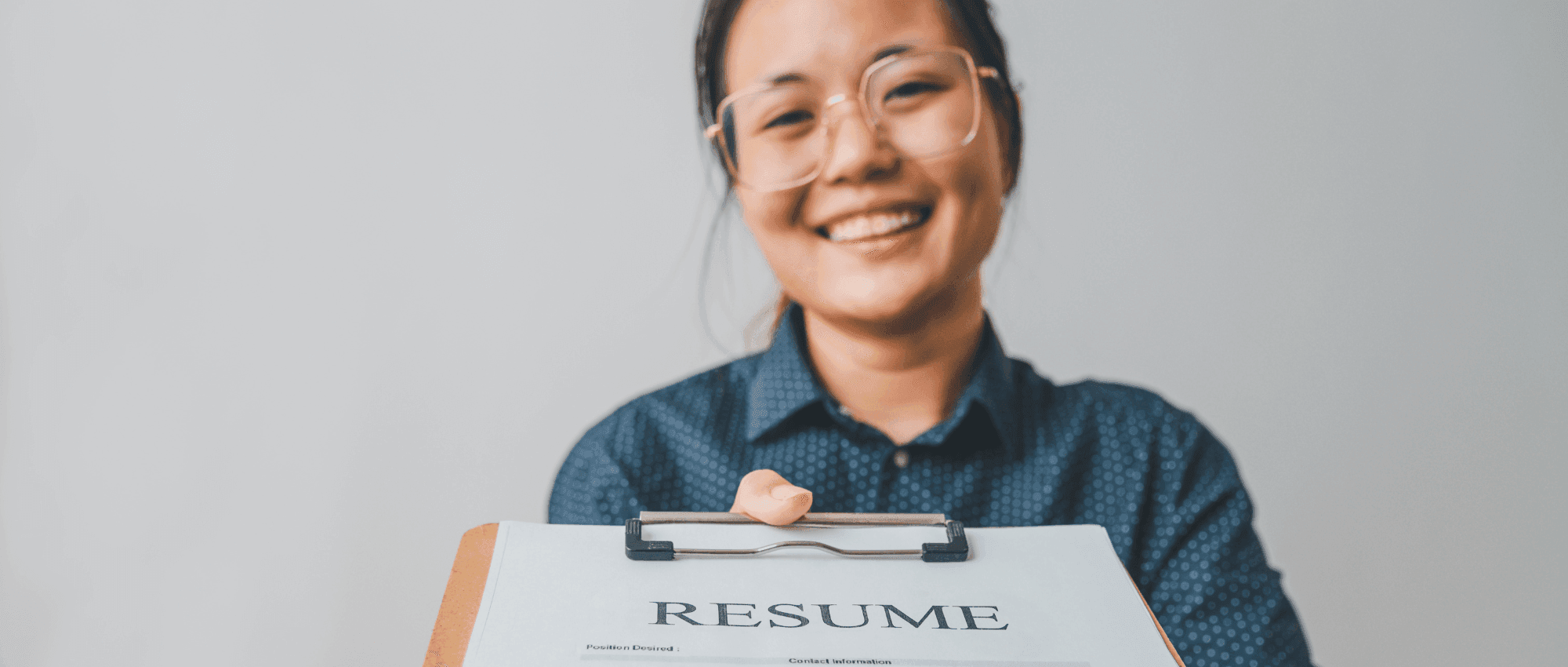 A lady smiling handing her resume