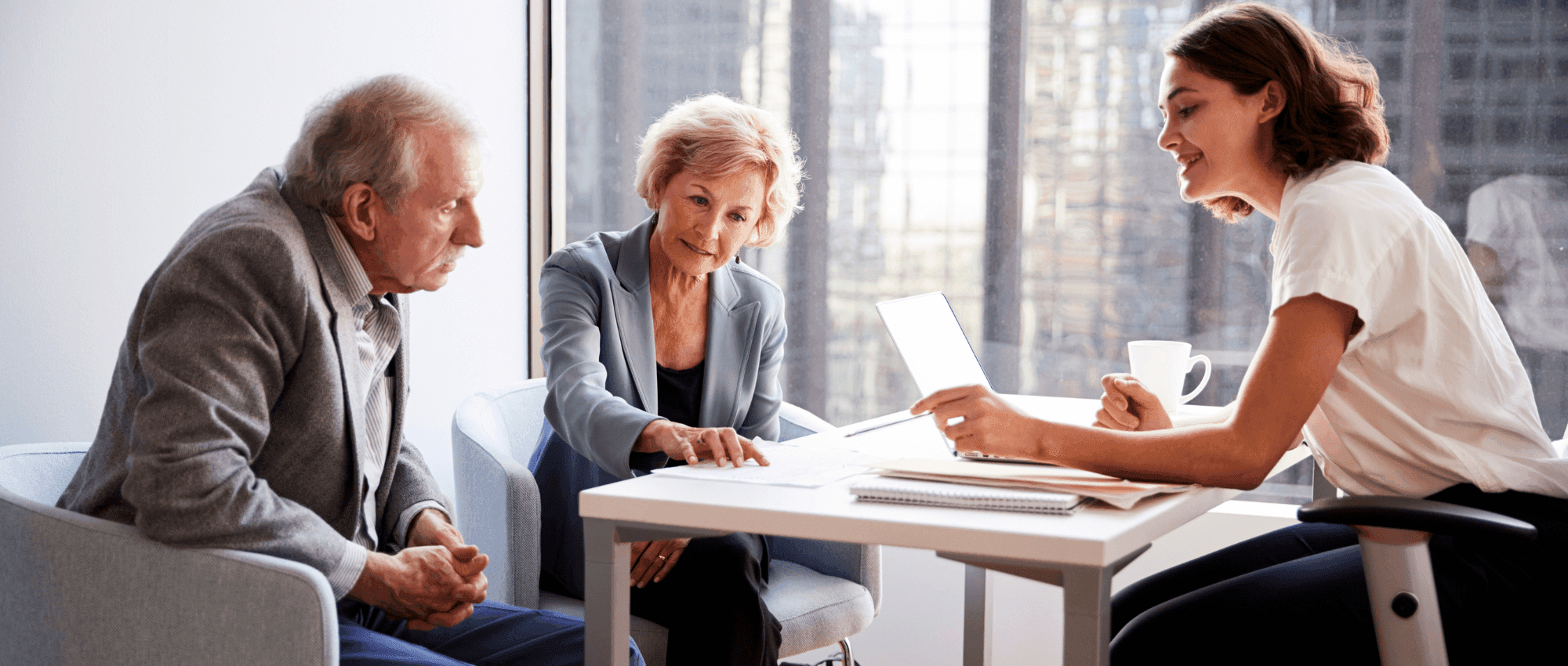 A lady explaining something to a senior couple