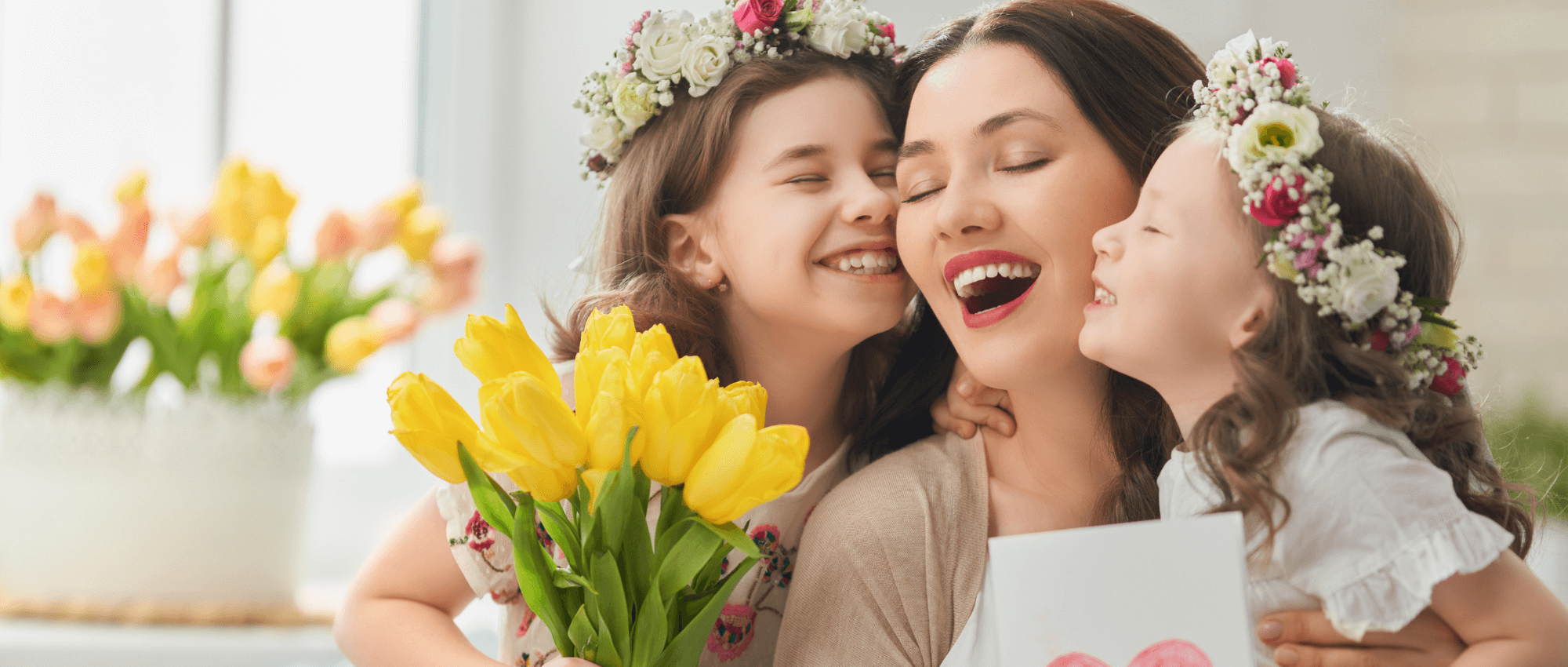 Two daughters kissing their mom