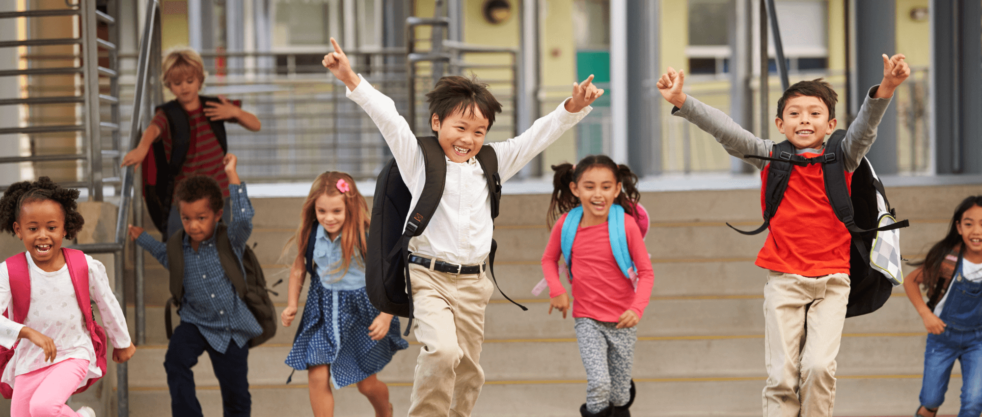 Children of different ethnicities jumping for joy at school