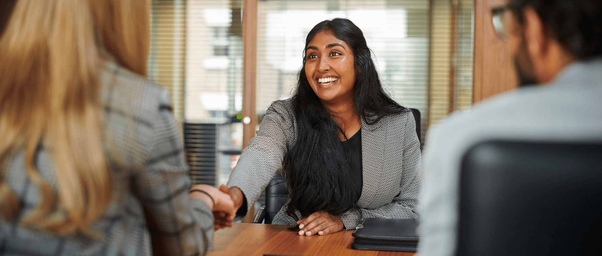 A person shaking hands with another in an interview