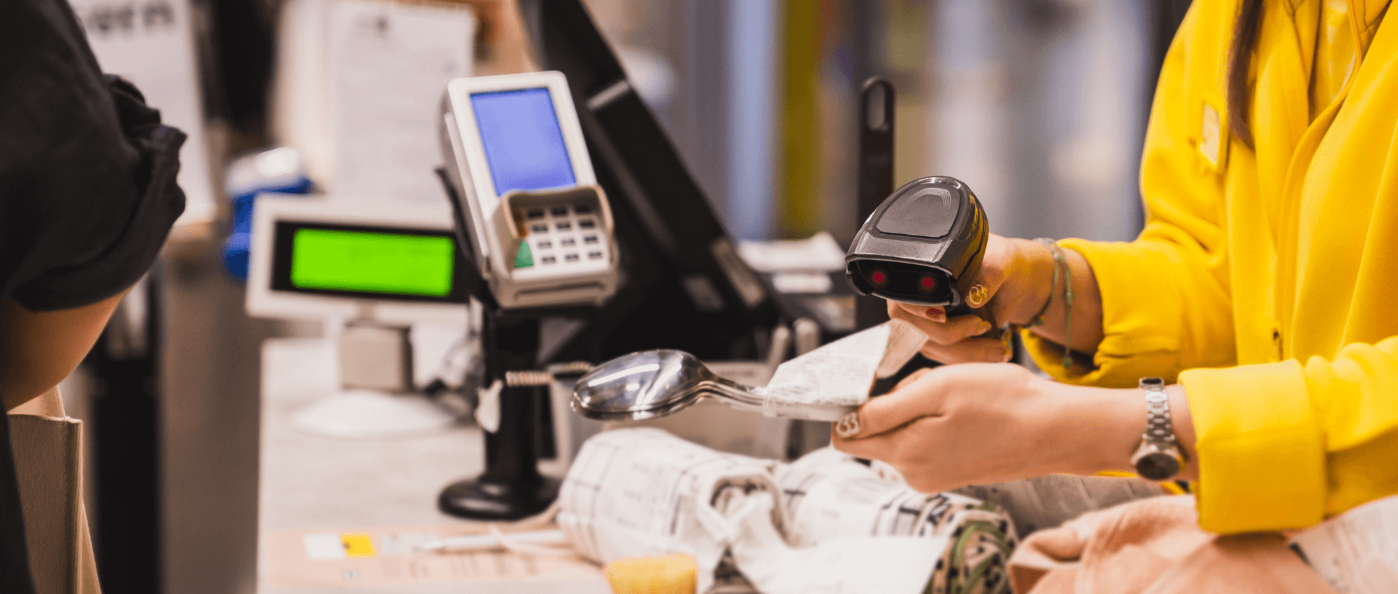 Cashier wearing yellow scanning an item